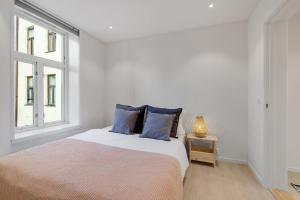 a bedroom with a bed with blue pillows and a window at Fantastic apartment in Oslo in Oslo