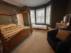 a bedroom with a bed and a chair and windows at Hotel 50 in Bournemouth
