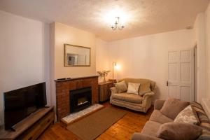 a living room with a couch and a fireplace at Birchmore House, by RentMyHouse 