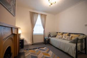 a living room with a bed and a window at Birchmore House, by RentMyHouse 