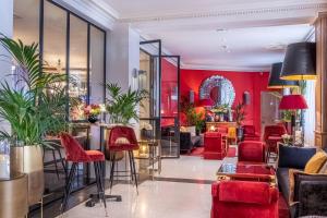 um átrio com cadeiras vermelhas e uma parede vermelha em Hotel Trianon Rive Gauche em Paris