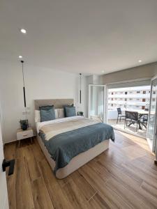 Apartamento Ronda III في فوينخيرولا: غرفة نوم بسرير كبير وطاولة