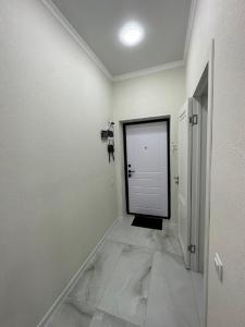 um corredor com uma porta branca num quarto em Абсолютно новая евродвушка в ЖК Комфортсити em Almaty