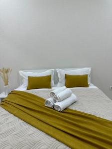 uma cama branca com toalhas e almofadas em Абсолютно новая евродвушка в ЖК Комфортсити em Almaty