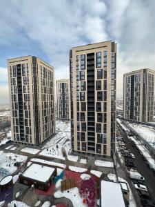 uma vista aérea de edifícios altos na neve em Абсолютно новая евродвушка в ЖК Комфортсити em Almaty