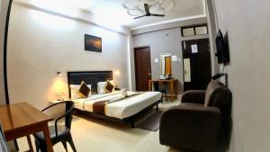a bedroom with a bed and a desk and a chair at HOLIDAYY INN in Prayagraj
