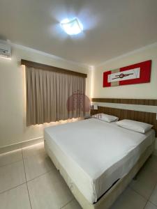 a bedroom with a large white bed in a room at L'acqua diRoma 12345 - Gualberto in Caldas Novas