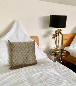 ein Bett mit einem Kissen und einer Lampe auf einem Tisch in der Unterkunft Apartment Living in Schwabach