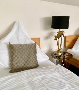 a bed with a pillow and a lamp on a table at Apartment Living in Schwabach