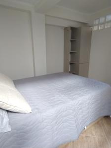 ein Schlafzimmer mit einem großen weißen Bett mit weißer Bettwäsche in der Unterkunft Jujuy Boutique in San Salvador de Jujuy + 3 Fotos