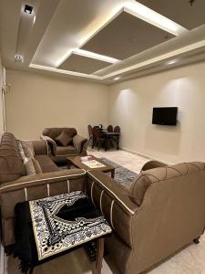 a living room with couches and a flat screen tv at Dosh Hotel in Al Madinah