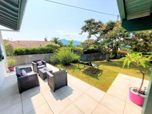 een patio met 2 stoelen en een tafel bij LE GARCIA villa au calme et vue sur les montagnes in Urrugne