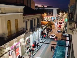 une rue de la ville la nuit avec des gens qui marchent dans la rue dans l'établissement Acre Urban Studios in Monastiraki, à Athènes