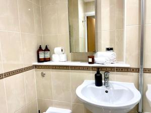 a bathroom with a sink and a mirror at Stylish Urban Escape Cardiff Bay Free Parking in Cardiff