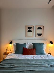 een slaapkamer met een bed met drie foto's aan de muur bij O live Athens in Athene