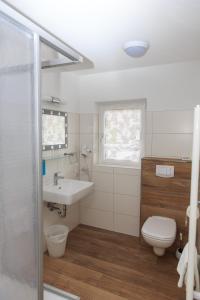a white bathroom with a sink and a toilet at Hotel Vulkanstüble in Achkarren