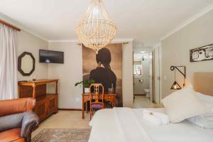 a bedroom with a bed and a desk and a chandelier at Atello Guesthouse in George
