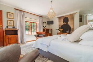 a bedroom with a large white bed and a chair at Atello Guesthouse in George