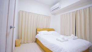 a bedroom with a bed with white towels on it at TOKYO SHINJUKU MIO HOTEL in Tokyo