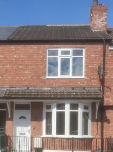 uma casa de tijolos com uma porta branca e janelas em Convenient 2 bedroom House in Darlington em Darlington
