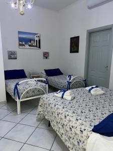 pokój z trzema łóżkami w pokoju w obiekcie Bella Mbriana w mieście Castellammare di Stabia