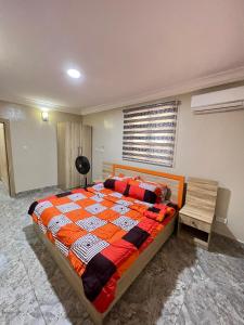 Mofide Queens Apartments (MQA) في Onigbongbo: غرفة نوم فيها سرير ومكتب