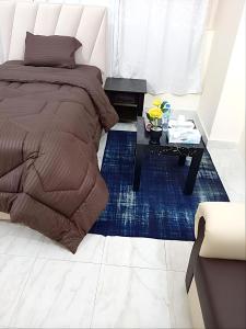 1 dormitorio con 1 cama y 1 mesa en MBZ - Pleasant Stay, en Abu Dabi