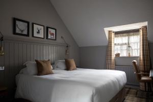 a bedroom with a large white bed and a window at The White Hart Ford in Ford