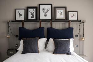 a bedroom with a bed with four pictures on the wall at The White Hart Ford in Ford