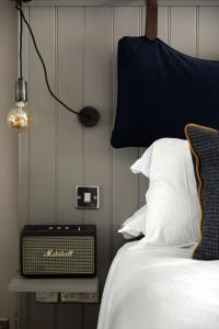 a bedroom with a bed and a radio on a table at The White Hart Ford in Ford