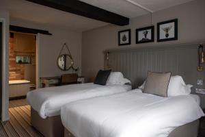 a hotel room with two beds and a mirror at The White Hart Ford in Ford
