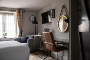 a bedroom with a bed and a desk and a mirror at The White Hart Ford in Ford