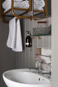 a bathroom with a white sink and towels at The White Hart Ford in Ford