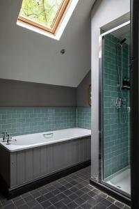 a bathroom with a tub and a shower with a window at The White Hart Ford in Ford