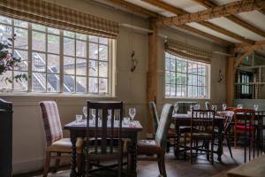 a dining room with tables and chairs and windows at The White Hart Ford in Ford