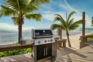a barbecue on the beach with palm trees at Incredible Beach Front Villa! in George Town