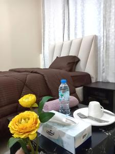 MBZ - Pleasant Stay في أبوظبي: وجود زجاجة مياه على طاولة بجوار أريكة
