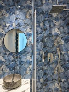 a bathroom with a shower with a sink and a mirror at Urban Elephant Suites in Thessaloniki