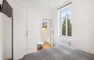 a white bedroom with a bed and a window at Ferienwohnung Maja in Loxstedt