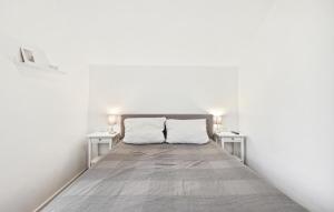 a bed in a white room with two tables at Ferienwohnung Maja in Loxstedt