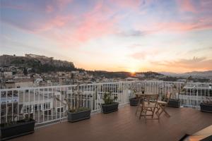 a balcony with a view of the city at sunset at Syntagma Unique Penthouse in Athens