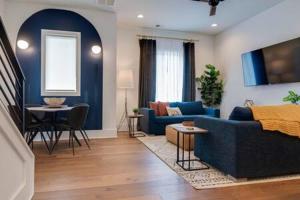 a living room with a blue couch and a table at Taylor Haus II - Stylish Stay with Rooftop, Close to Fun in Nashville