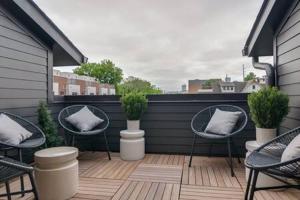 a patio with chairs and pillows on a deck at Taylor Haus II - Stylish Stay with Rooftop, Close to Fun in Nashville