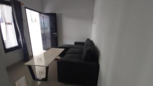 a living room with a black couch and a table at Chandra's House in Denpasar +1 photo