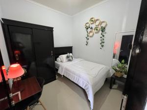 a bedroom with a bed and a black cabinet at Chandra's House in Denpasar