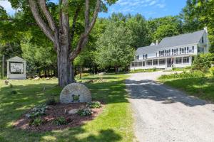 a house with a tree and a gravel driveway at Inn on Golden Pond in Holderness