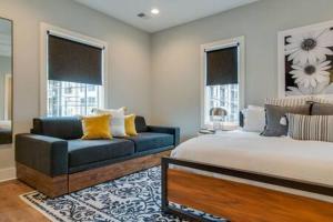 a bedroom with a bed and a couch and windows at The Taylors - Grand Getaway for 22 in Germantown in Nashville