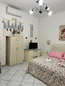 sypialnia z łóżkiem, biurkiem i telewizorem w obiekcie Bella Mbriana w mieście Castellammare di Stabia