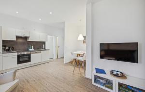 LoxstedtにあるFerienwohnung Majaの白いキャビネットとテーブルと椅子のあるキッチン