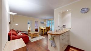uma cozinha e uma sala de estar com um sofá vermelho em strandnahe FeWos mit 2 Schlafzimmern und Terrasse oder Balkon, Caspar David, Binz em Binz